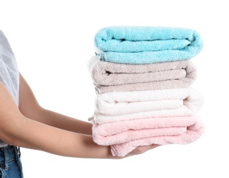 Photo of Young woman holding clean towels on white background, closeup. Laundry day