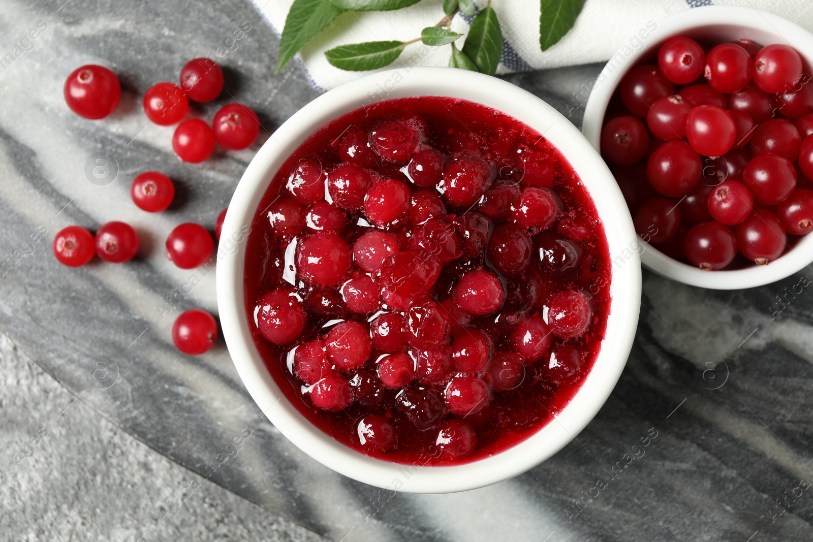 Photo of Flat lay composition with cranberry sauce and fresh berries on marble board