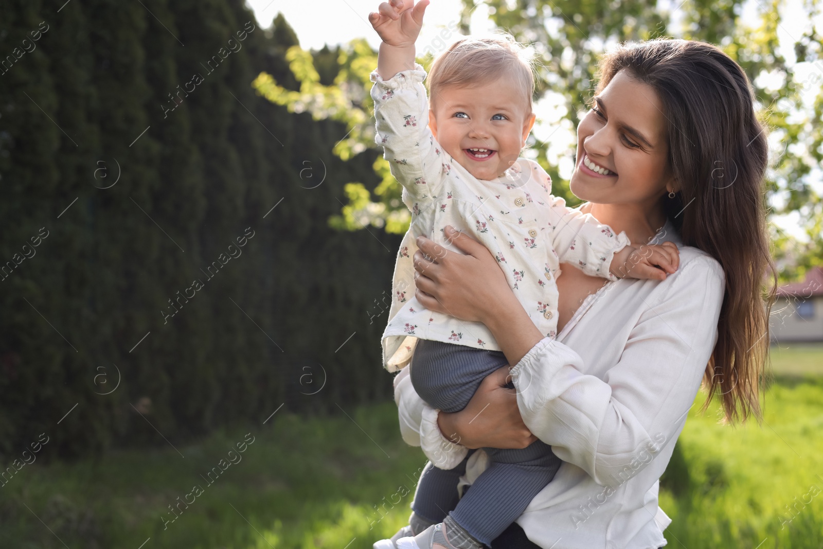 Photo of Happy mother with her cute baby in park on sunny day, space for text