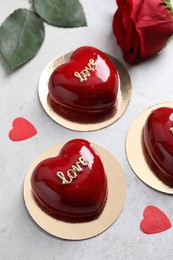 Photo of St. Valentine's Day. Delicious heart shaped cakes and rose on light table, flat lay