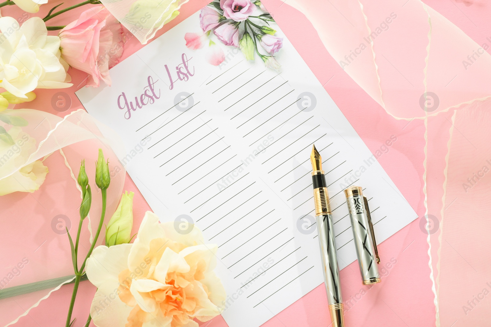 Photo of Guest list, pen, tulle fabric and beautiful flowers on pink background, flat lay. Space for text