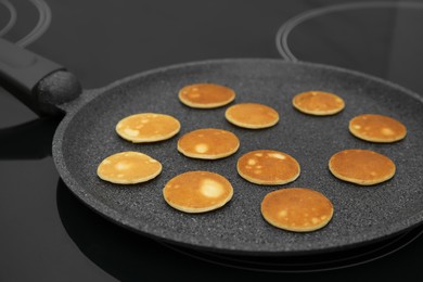 Photo of Frying tasty cereal pancakes on modern stove