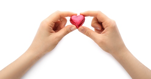 Photo of Woman holding heart shaped chocolate candy on white background, closeup