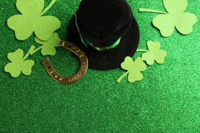 Flat lay composition with leprechaun hat on green glitter background, space for text. St Patrick's Day celebration