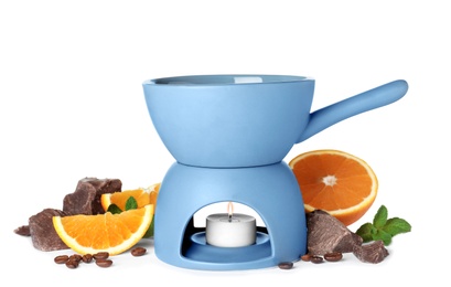 Fondue pot with chocolate and fruits on white background