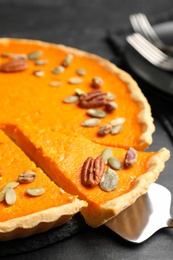 Photo of Delicious homemade pumpkin pie on black table, closeup