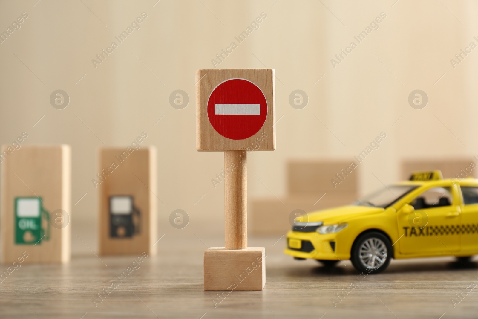 Photo of Traffic sign No entry and toy taxi car on wooden table. Passing driving license exam