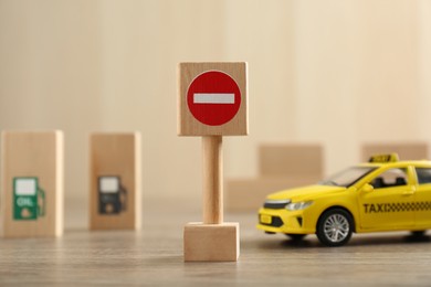 Traffic sign No entry and toy taxi car on wooden table. Passing driving license exam