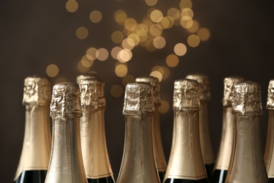 Many bottles of champagne on blurred background, closeup