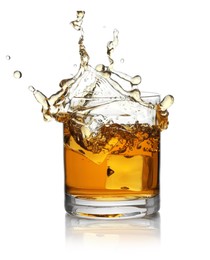 Photo of Whiskey splashing out of glass on white background