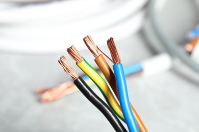 Photo of Colorful electrical wires on blurred background, closeup