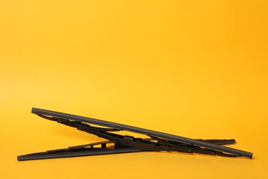 Photo of Car windshield wipers on yellow background. Space for text