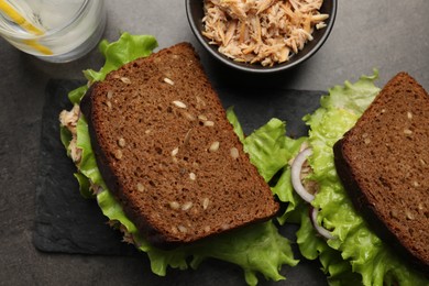 Photo of Delicious sandwiches with tuna and vegetables on light grey table, flat lay