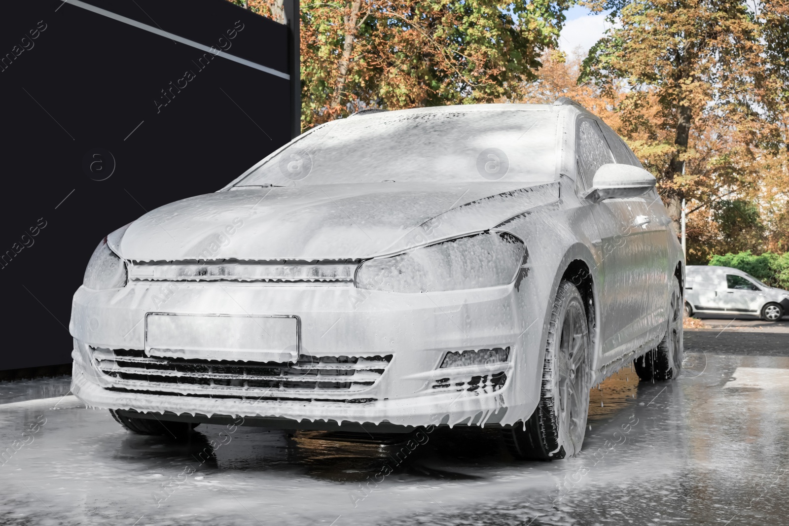 Photo of Auto with cleaning foam at outdoor car wash