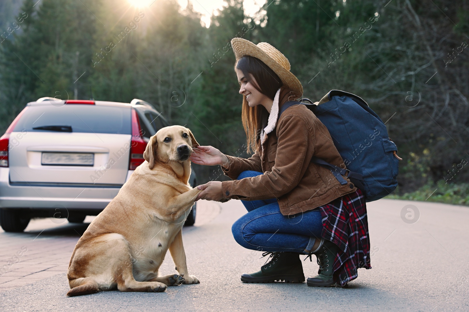 Photo of Happy woman and adorable dog on road. Traveling with pet