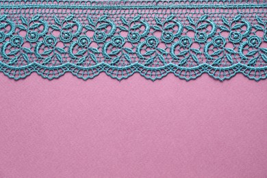 Photo of Green lace on purple background, top view. Space for text