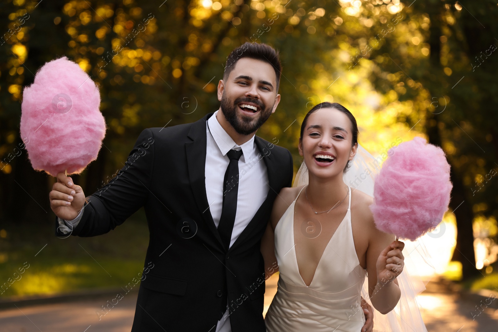 Photo of Happy newlywed couple with cotton candies in park