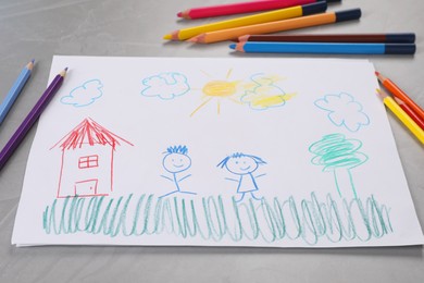 Photo of Cute child`s drawing and colorful pencils on grey textured table
