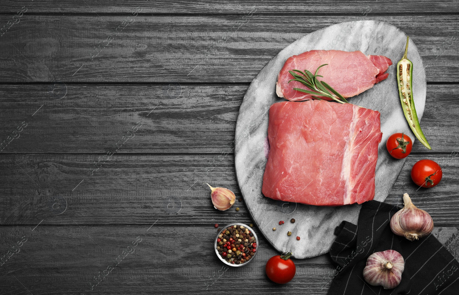 Photo of Flat lay composition with fresh raw cut meat on black wooden table. Space for text