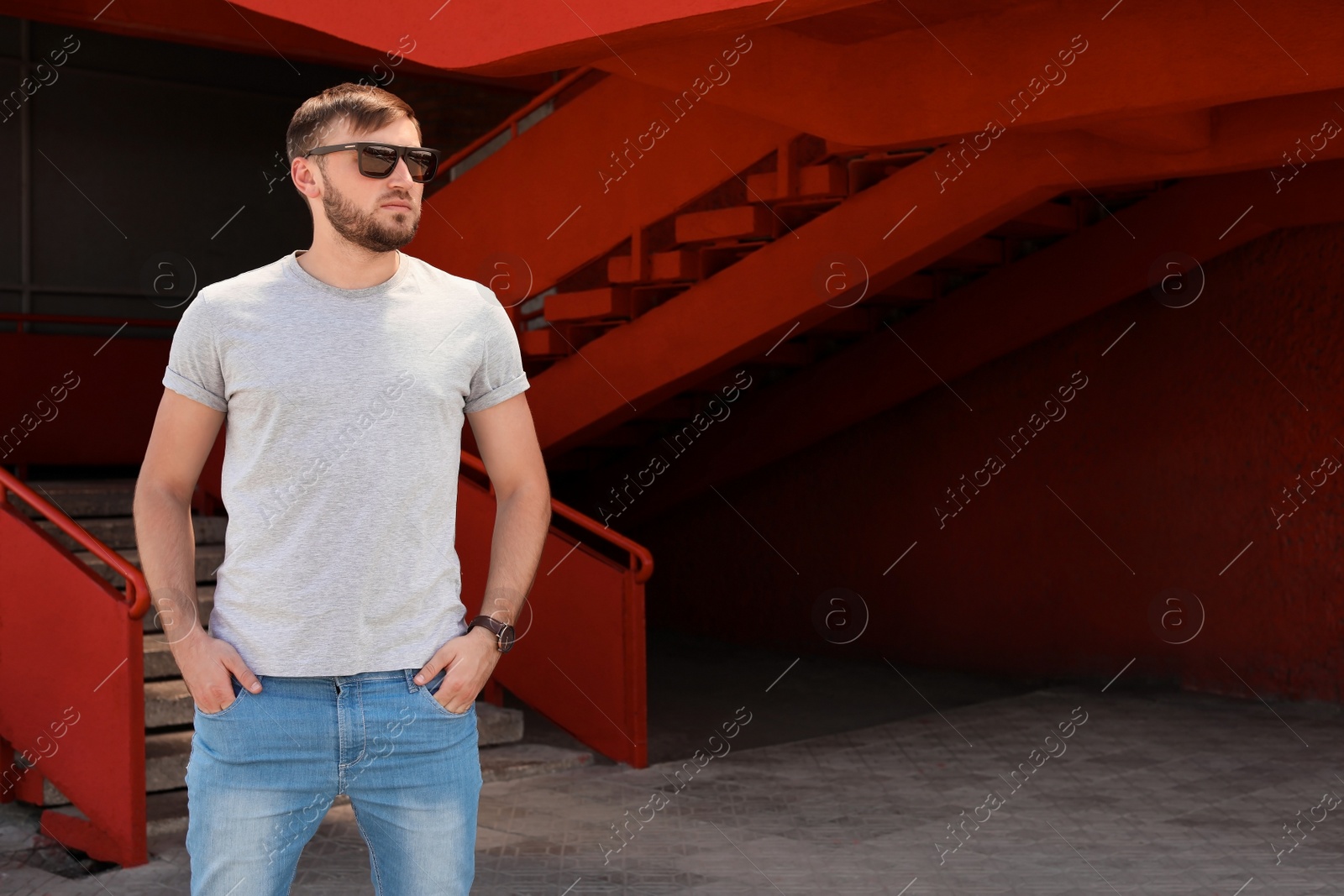 Photo of Young man wearing gray t-shirt on street. Urban style