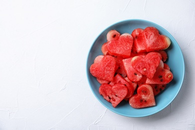 Photo of Plate with heart shaped watermelon slices on light background, top view