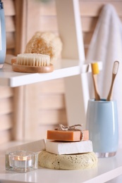 Photo of Soap and toiletries on wooden shelves in bathroom