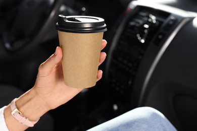 Photo of Coffee to go. Woman with paper cup of drink in car, closeup and space for text