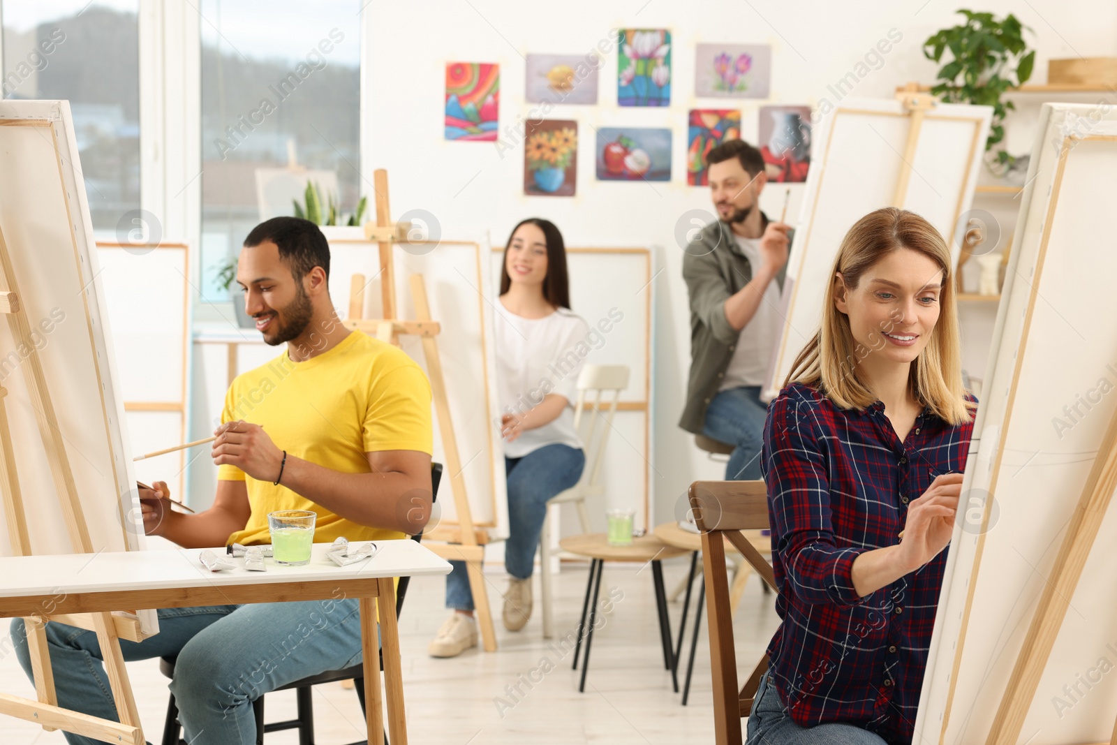 Photo of Group of students attending painting class in studio. Creative hobby