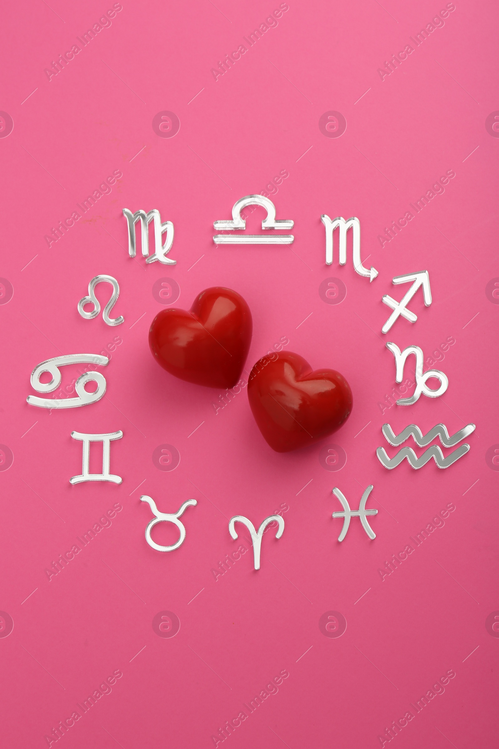 Photo of Zodiac signs and red hearts on pink background, flat lay