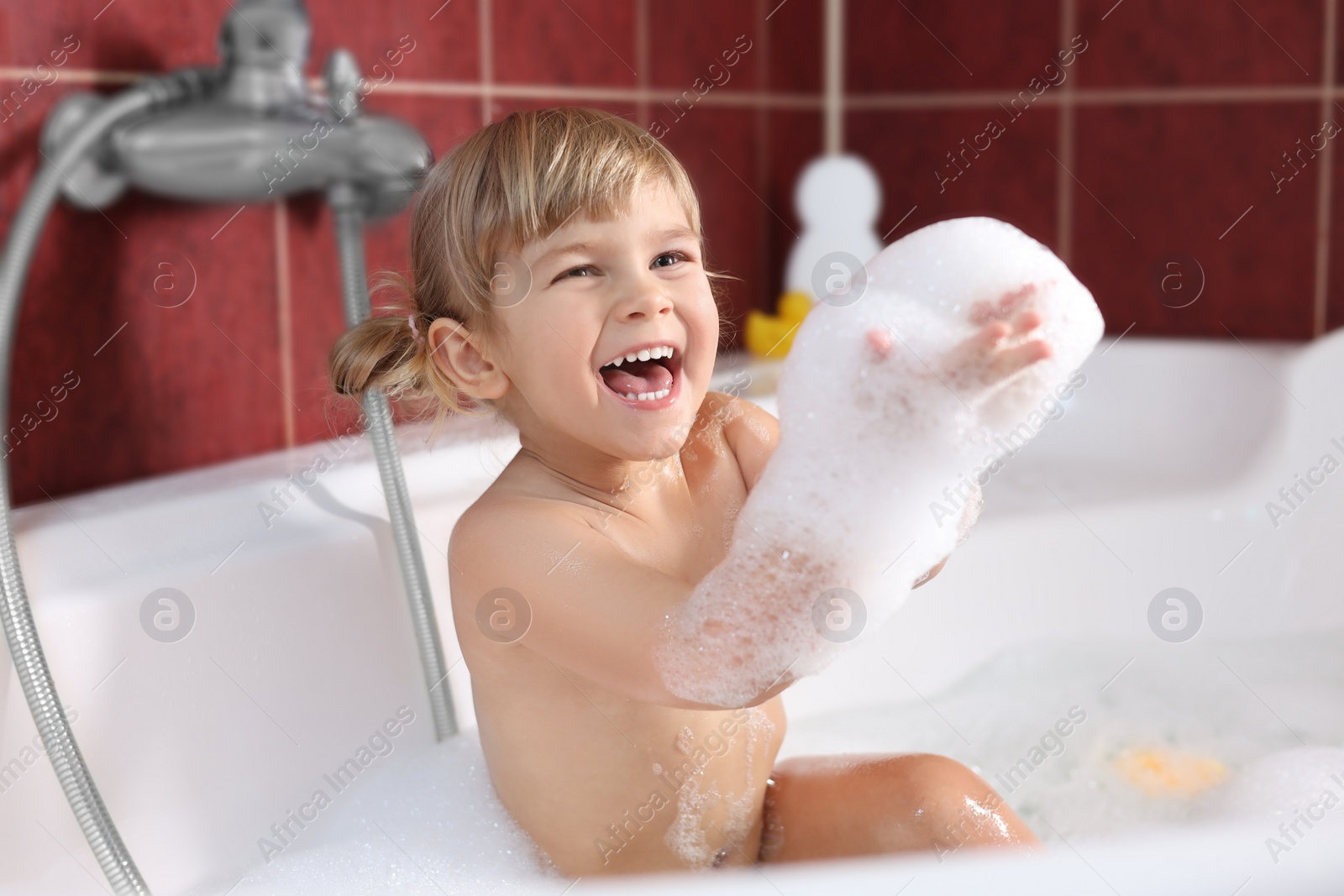 Photo of Happy girl having fun in bathtub at home