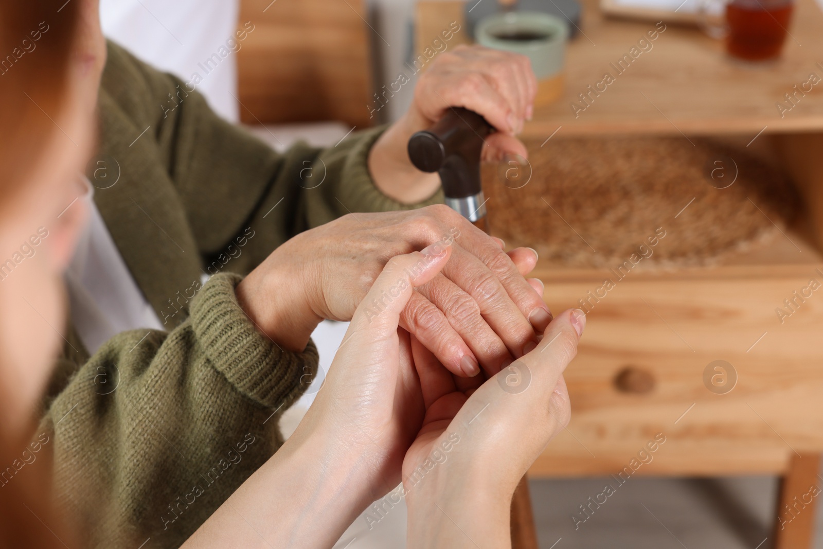 Photo of Caregiver and elderly woman with walking cane at home, closeup