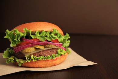 Photo of One tasty burger on wooden table. Space for text