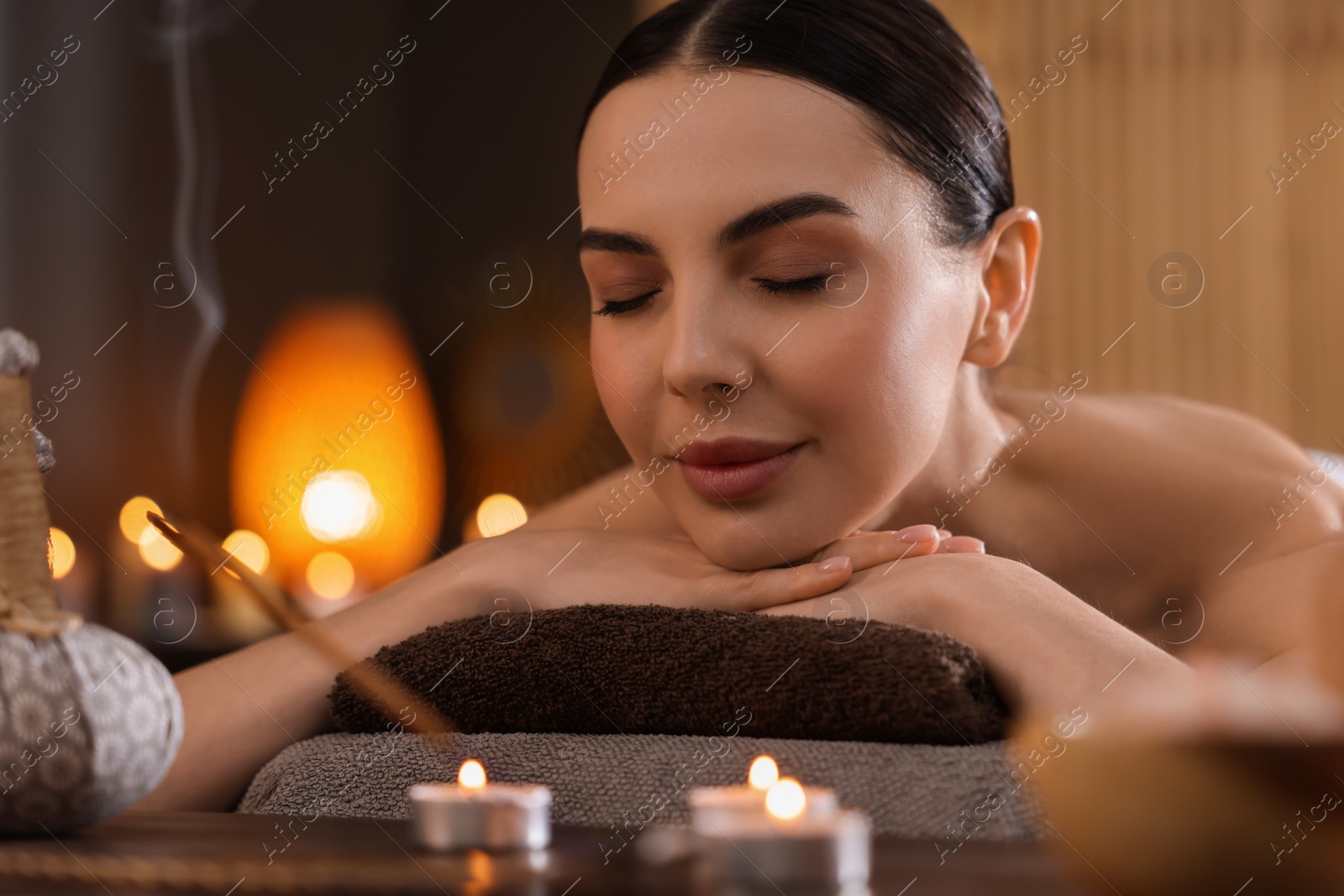 Photo of Spa therapy. Beautiful young woman lying on massage table in salon