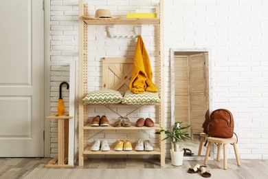 Cozy hallway interior with wooden shelving unit. Stylish design idea