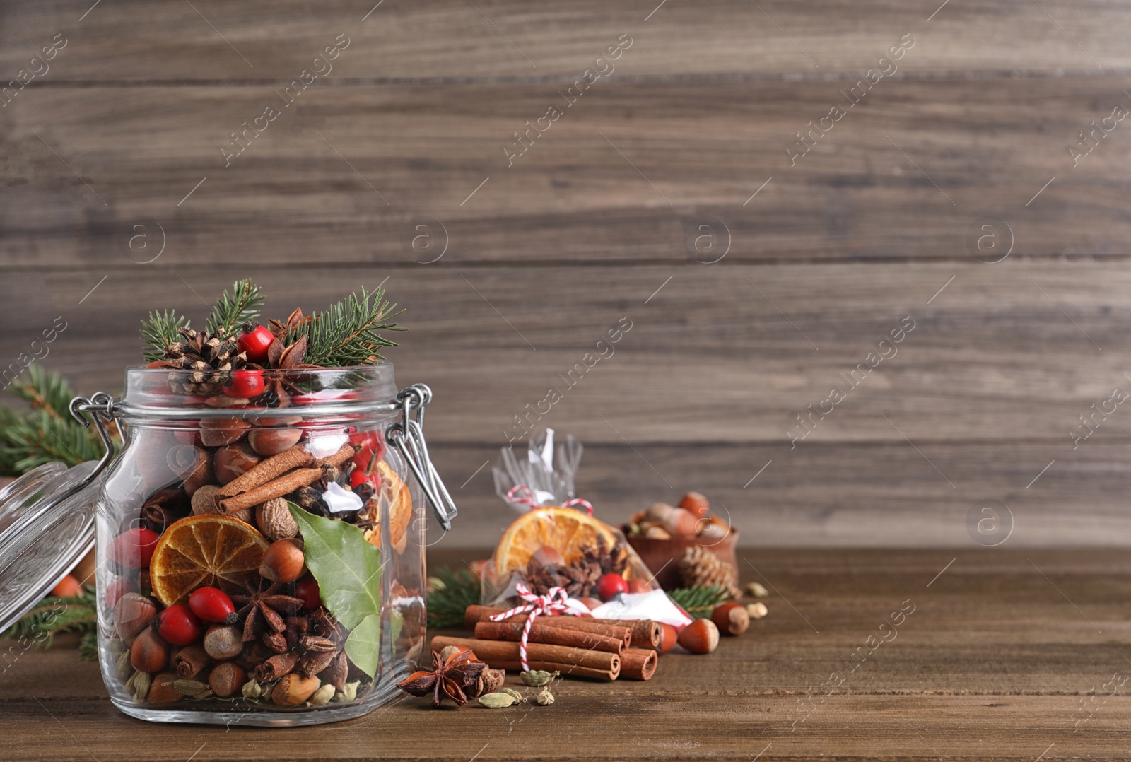 Photo of Aroma potpourri with different spices on wooden table, space for text