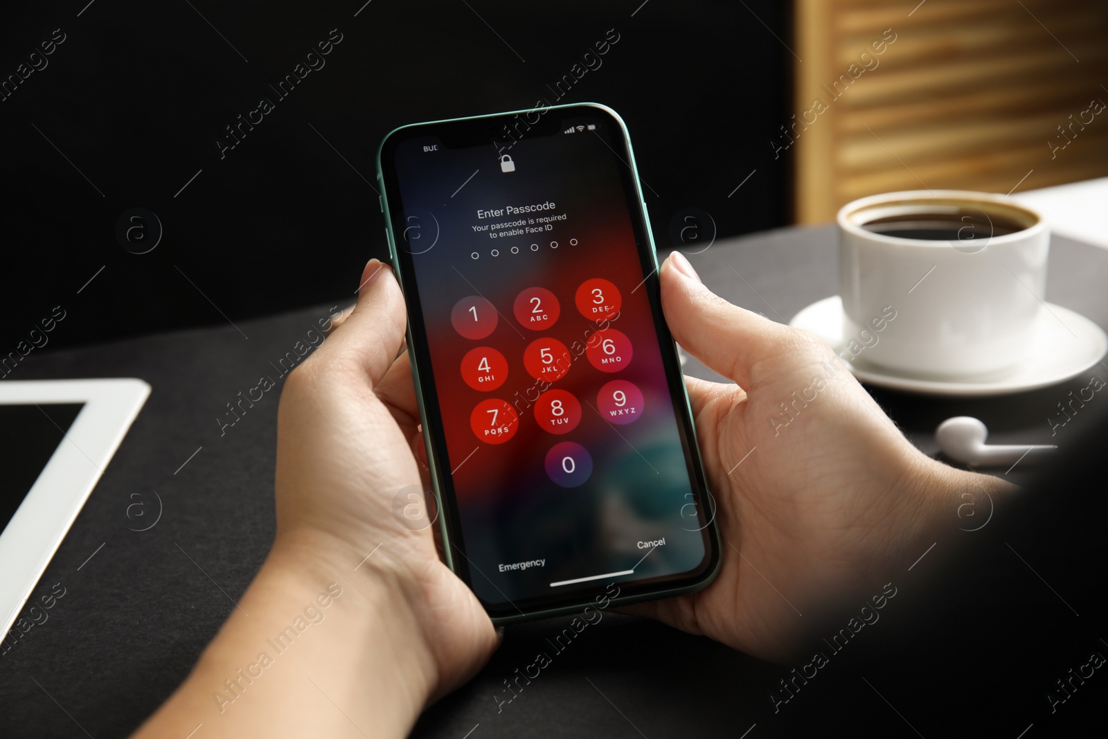 Photo of MYKOLAIV, UKRAINE - JULY 9, 2020: Woman holding Iphone 11 with numpad for entering passcode  on screen at black table, closeup