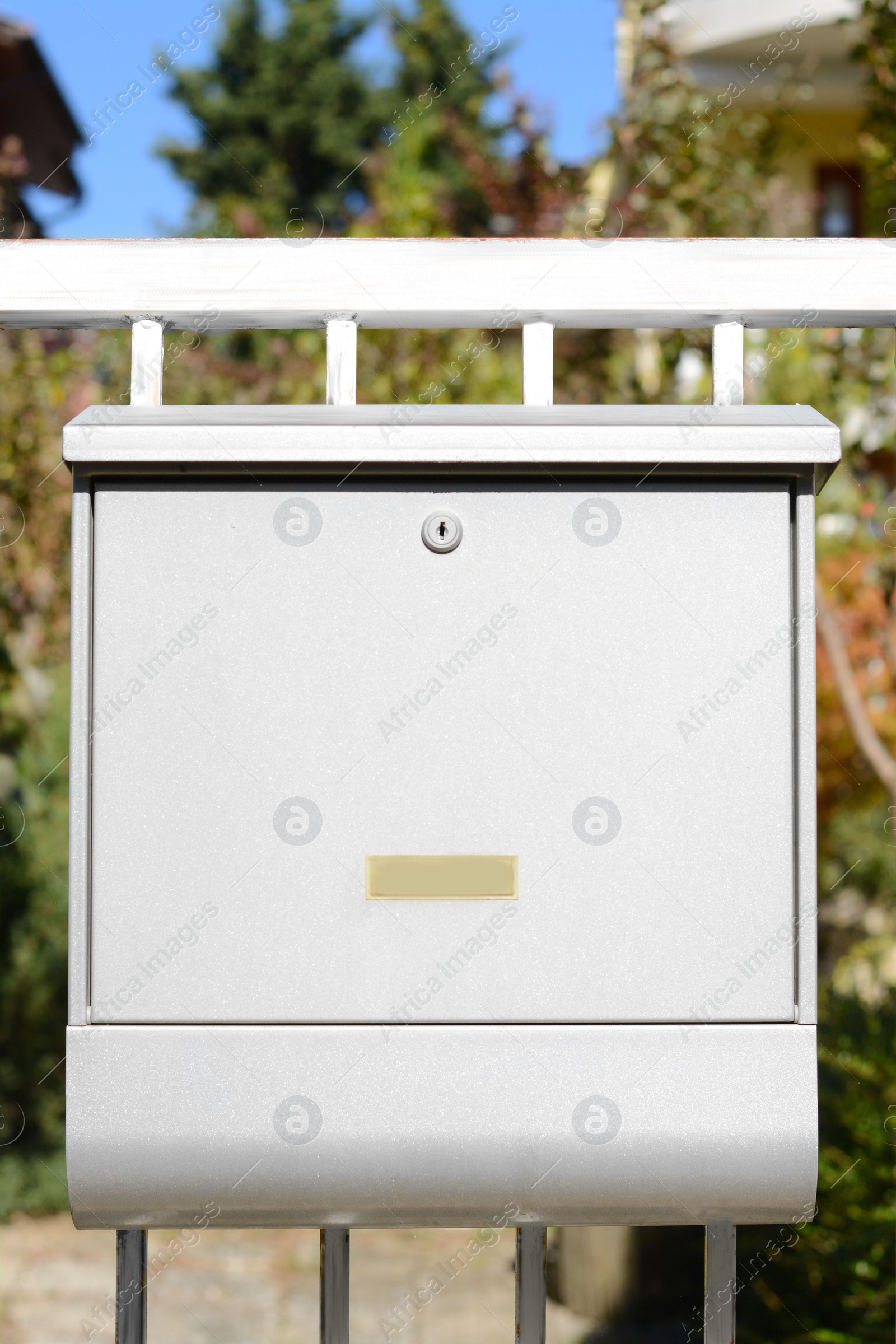 Photo of White metal letter box on fence outdoors