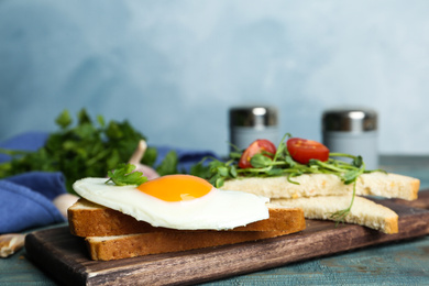 Photo of Tasty fried egg with bread on wooden board