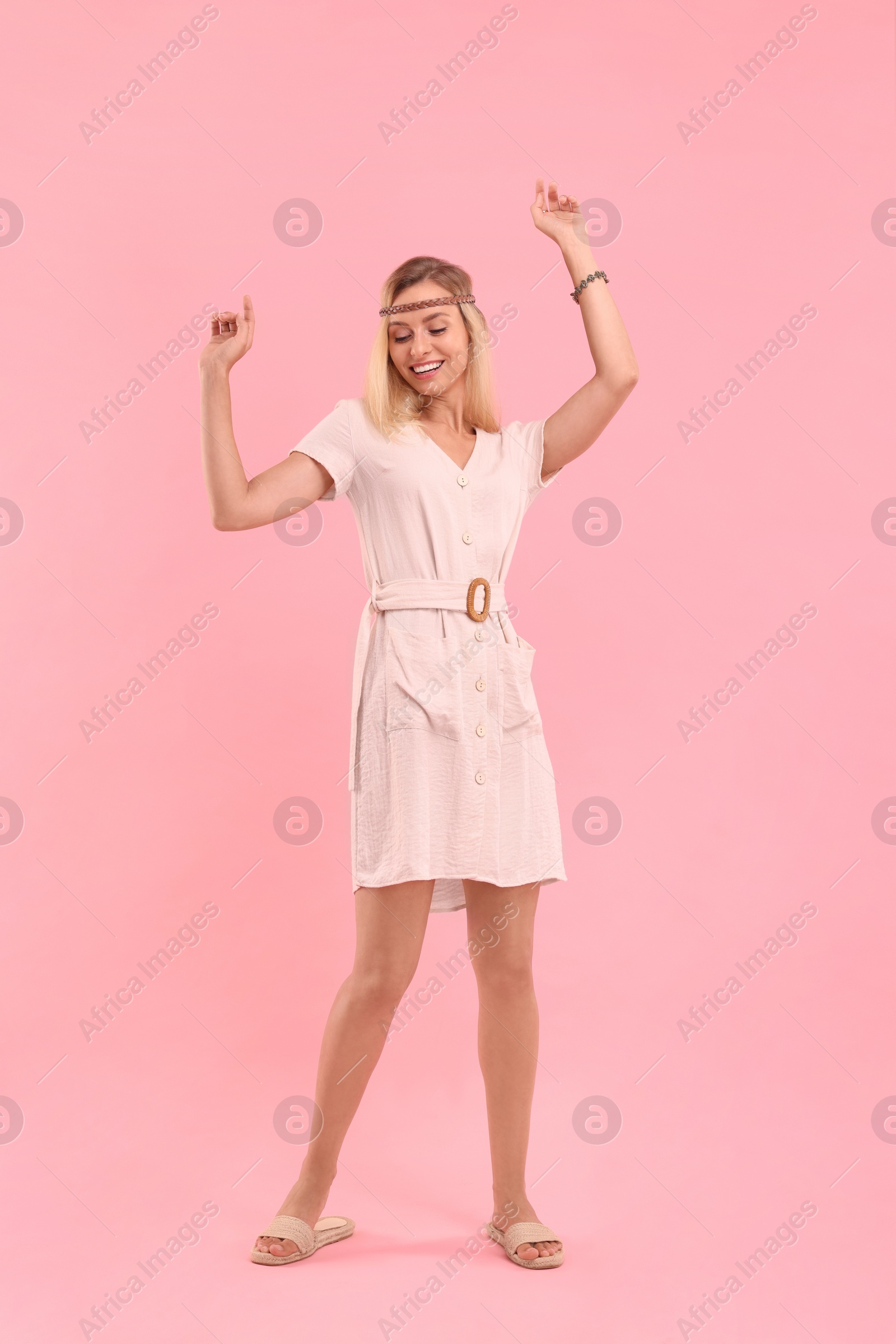 Photo of Happy hippie woman dancing on pink background