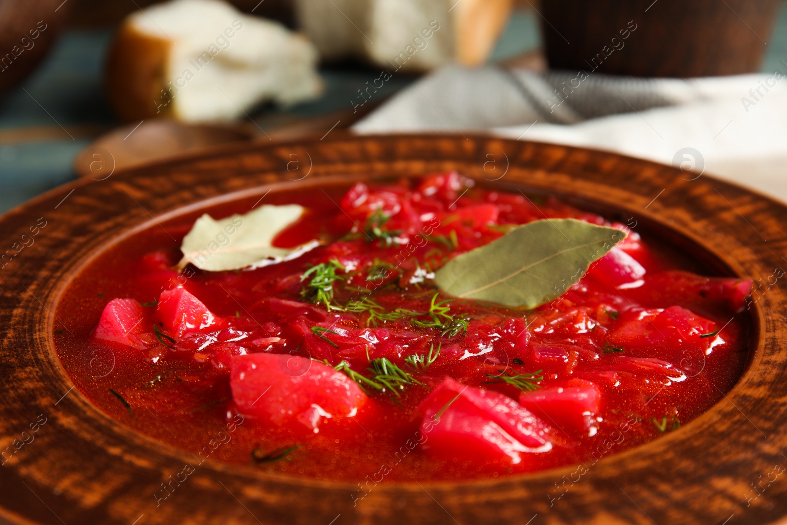 Photo of Stylish brown clay plate with Ukrainian borsch, closeup