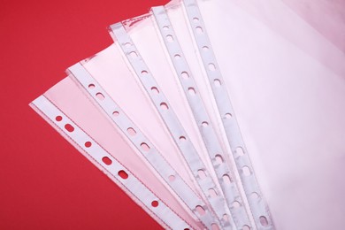 Photo of Empty punched pockets on red background, above view
