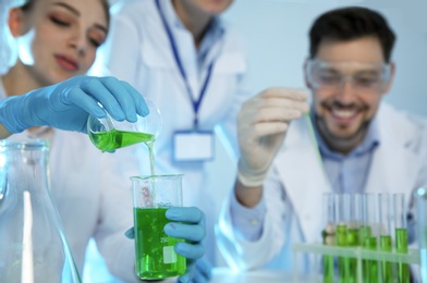 Group of scientists working with sample in chemistry laboratory, closeup