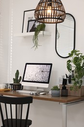 Photo of Cozy workspace with computer on wooden desk at home