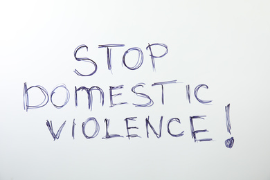 Phrase STOP DOMESTIC VIOLENCE on white background, top view