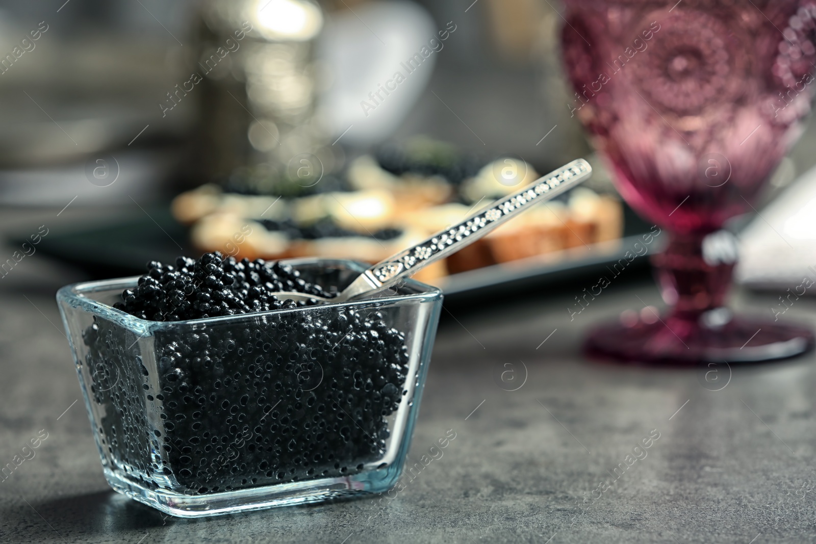 Photo of Glass bowl with black caviar on table