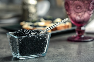 Glass bowl with black caviar on table