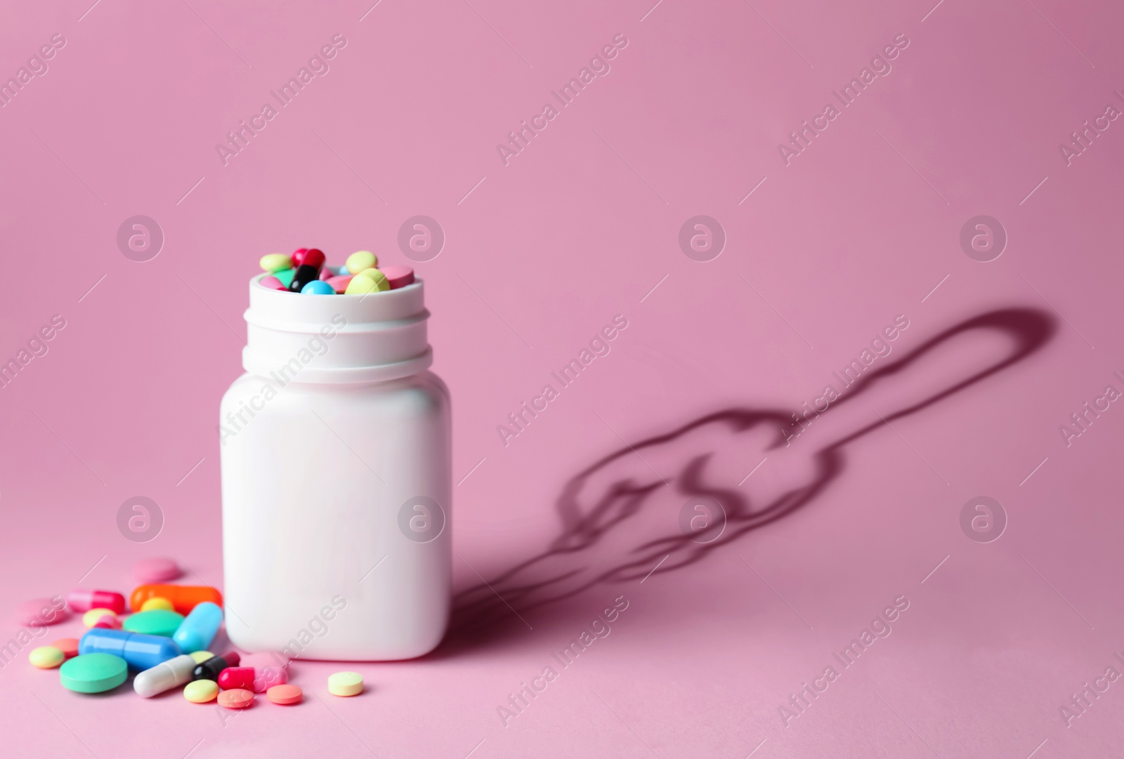 Image of Doping concept. Plastic bottles with pills and silhouette of sportsman on pink background