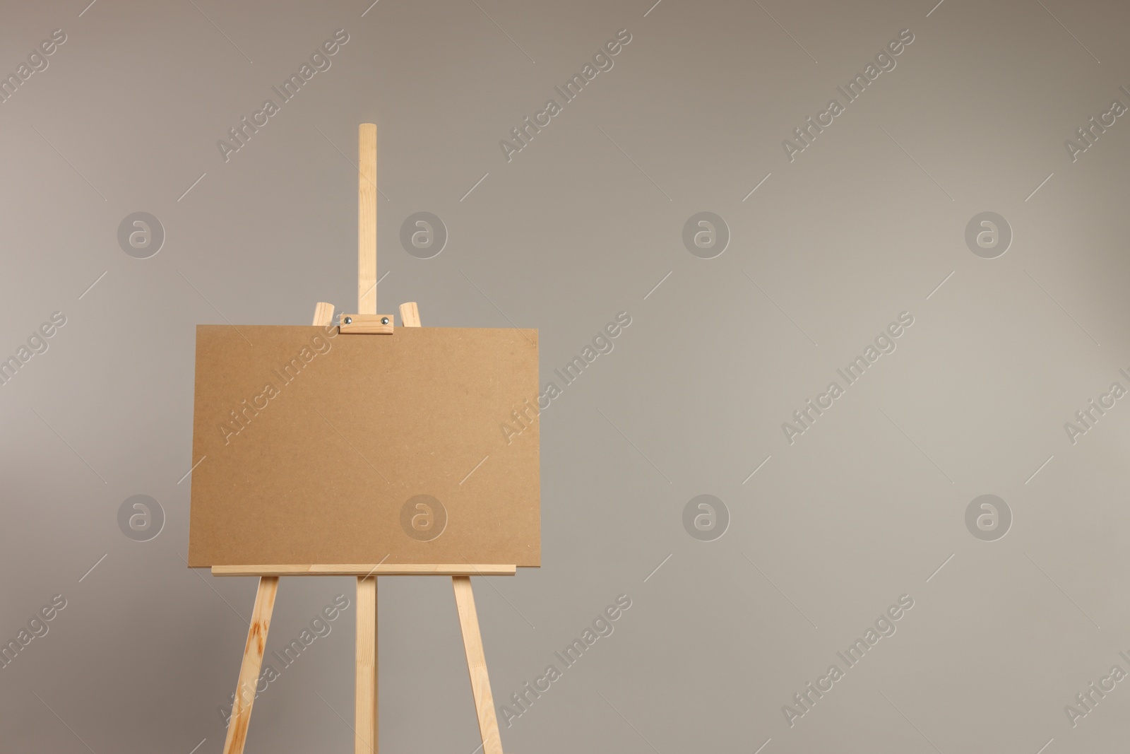 Photo of Wooden easel with blank board on grey background. Space for text