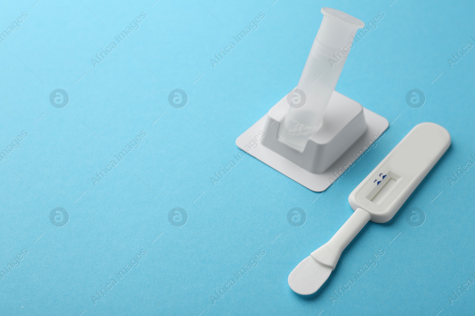 Photo of Disposable express test kit on light blue background. Space for text