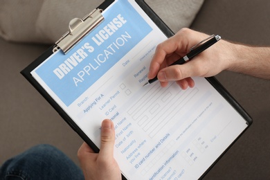 Man filling in driver's license application form, closeup